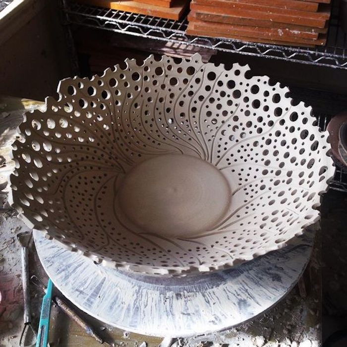 una grande ciotola di ceramica, una ciotola con fori, strumenti per tagliare e modellare