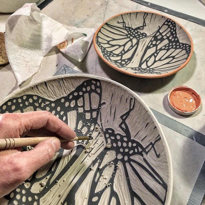 Ceramista professionista che disegna e dipinge lastre ceramiche