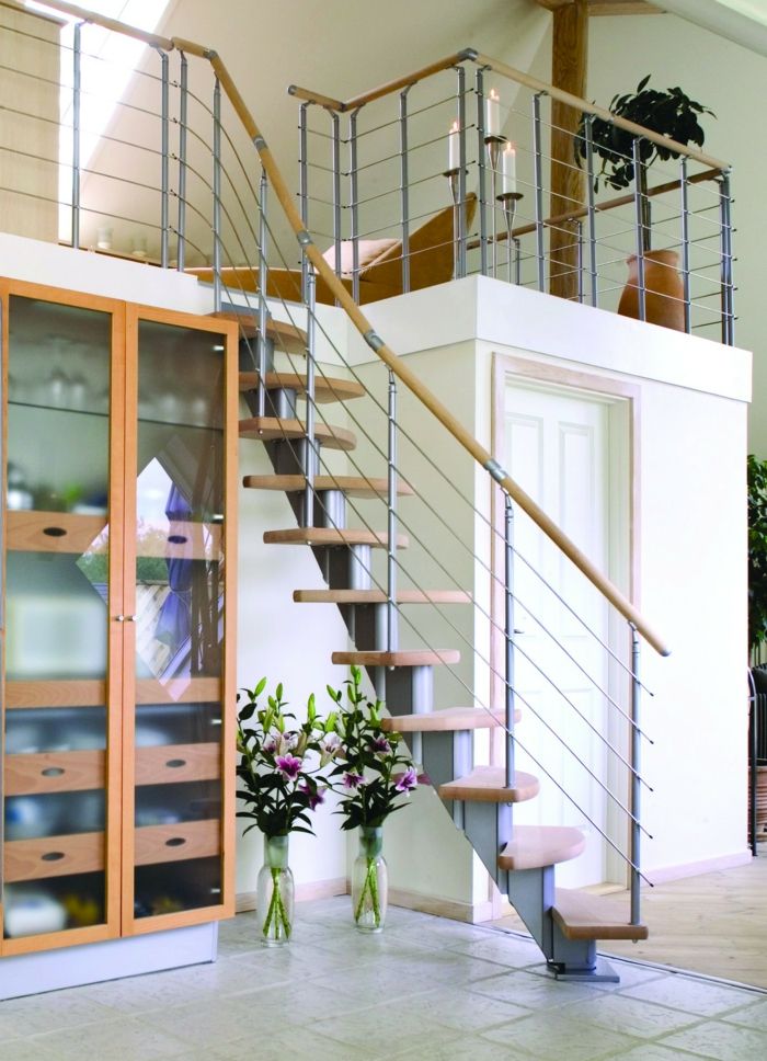 cam duvarlı bir raf, küçük merdivenler ve çiçekli cam vazolar