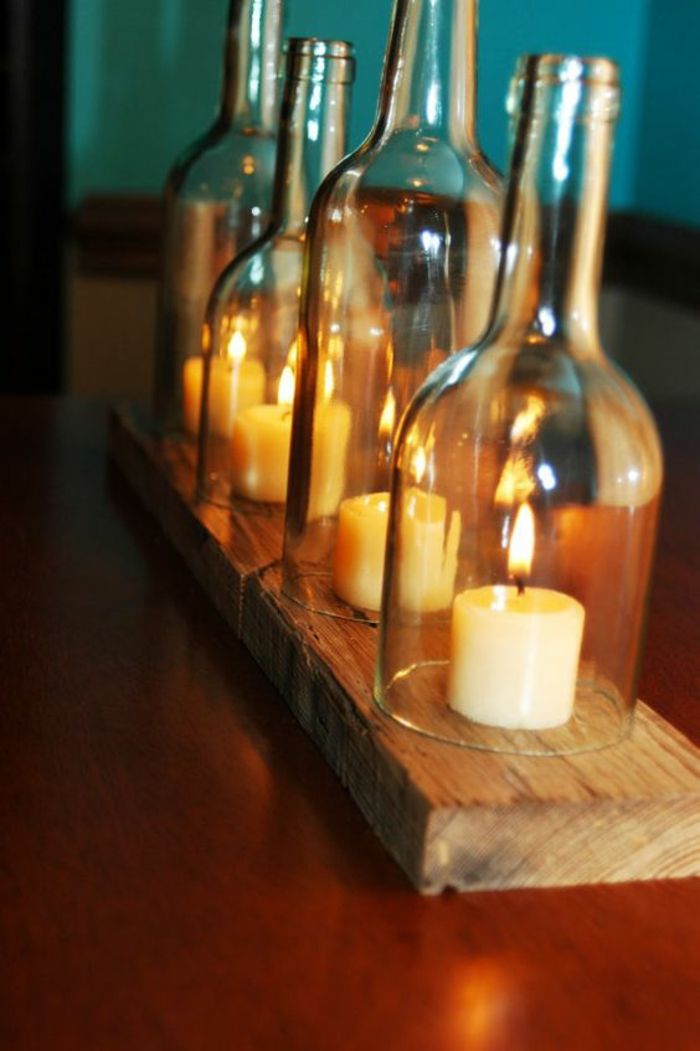 krásne sviečky zo sviečok vyrobené zo sklenených fliaš a dreva