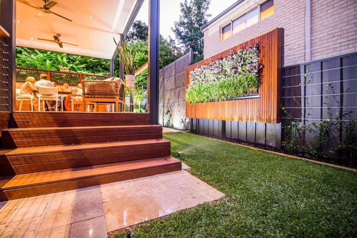 ett modernt hus med vertikal plantering som väggmålning i trädgården
