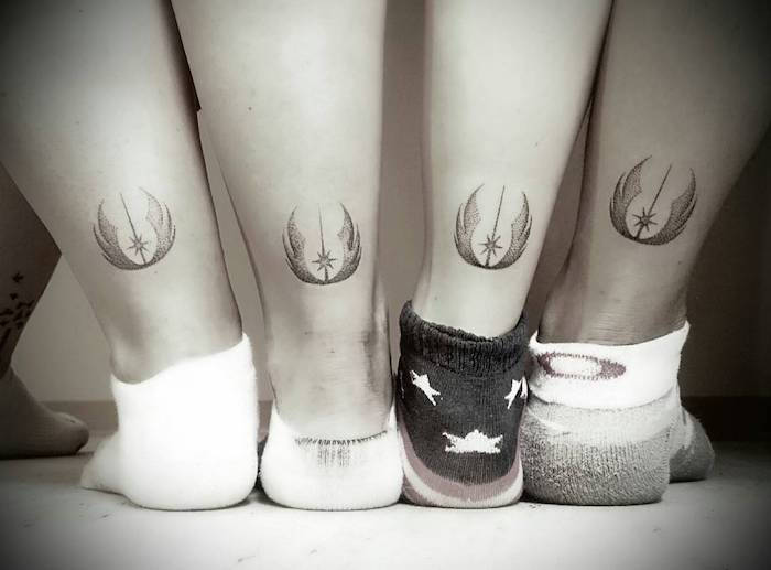 Štyri nohy s malým čiernym hviezdnym bojovým tetovaním s čiernym logom a vesmírnou loďou
