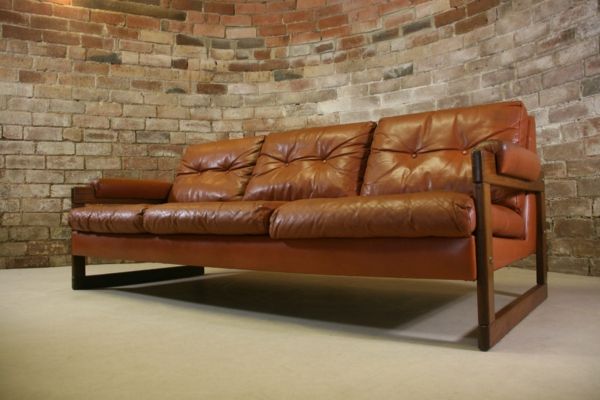 vintage-usnjeno-pohištvo-kavč-v-rjave-odtenki-opeko steno za njim