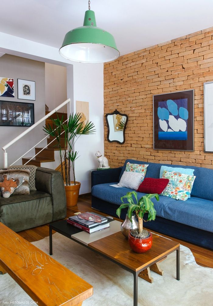 Idee di arredamento in stile vintage, soggiorno, divano blu con cuscini decorativi, piante da interno, panca e tavolo in legno