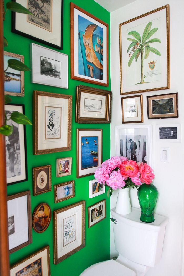 Stile vintage, un muro in verde, molte foto e foto, vasi con fiori