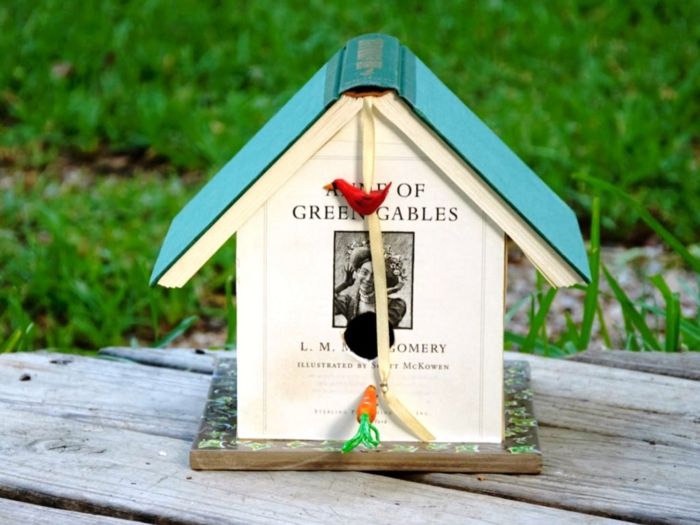 Nestkast gemaakt van boeken, creatief decoratie-idee voor kinderen en volwassenen, rood vogeltje en kleine wortel
