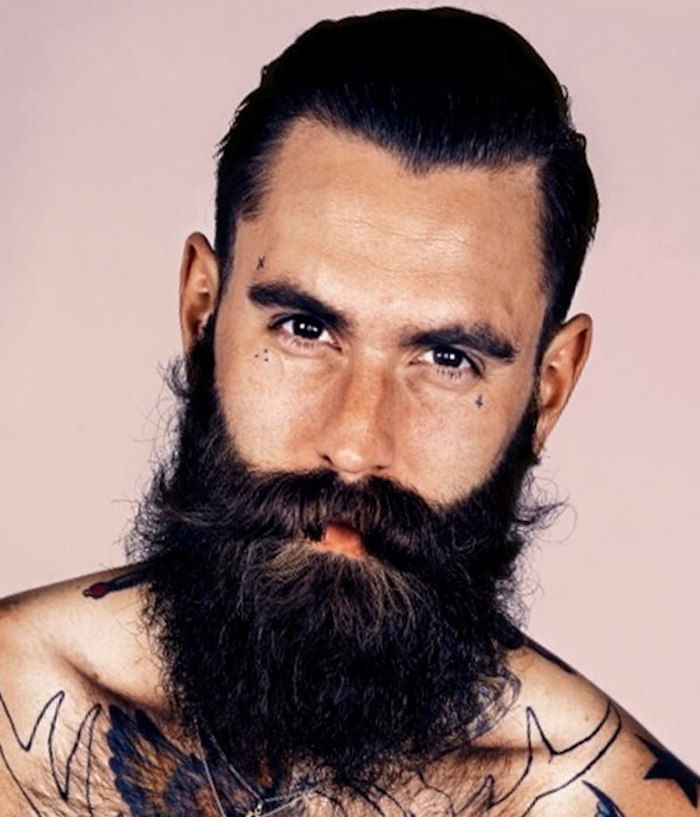 attraktiv mann med bryst tatoveringer, svart langt skjegg, stjerne tatovering, tan tatovering
