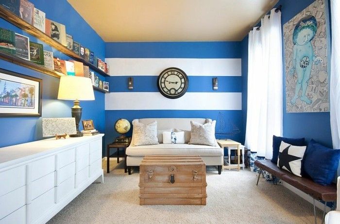 väggdesign-med-färg vardagsrum-vit-skåp trä bänk soffa-vita bokhyllor-blå-vit vägg