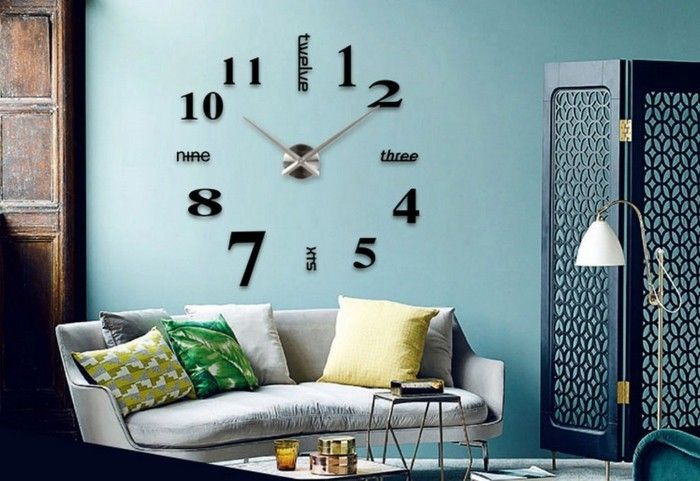 duvar saatlik xxl büyük siyah haneli metal işaretçi-açık mavi-duvar-beyaz-kanepe-renkli-yastık-İspanyolca-duvar