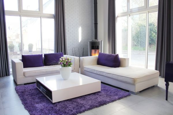 balta sofa-su-sofos-pagalvėlėmis-violetinės spalvos stiklo sienos-minkštas kilimas