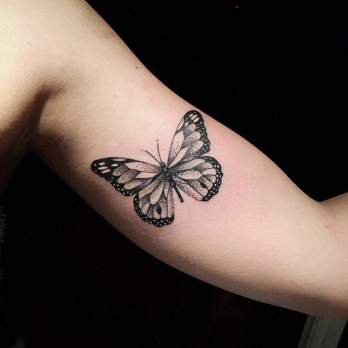 rankena su juoda tatuiruočių drugeliu - čia yra plaukiojantis juodas drugelis su dideliais juodais sparnais