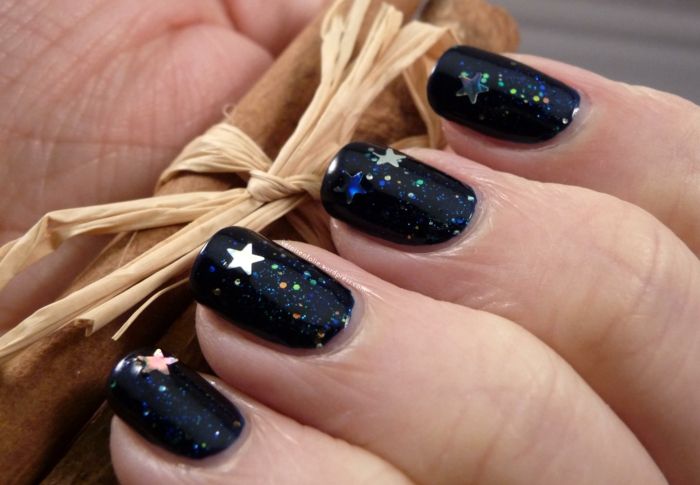 Zimski bleščeči nohti v temno modri barvi z malo zvezdami, ideja za novoletno manikuro
