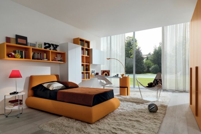 miegamojo baldai - oranžinė sofa ir stiklo siena
