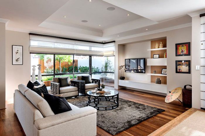 tv-paneel kleurrijke woonkamer woonkamer thuis bank wit met zwarte kussens ronde tafel tapijt muur decor